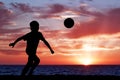 Silhouette of a boy playing football or soccer at Royalty Free Stock Photo
