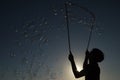 Silhouette boy playing witah a bubble wand Royalty Free Stock Photo