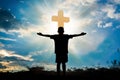 Silhouette of boy praying to a cross with heavenly cloudscape sunset concept for religion, worship, love and spirituality Royalty Free Stock Photo