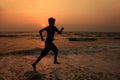 A boy runs along the beach during sunset Royalty Free Stock Photo