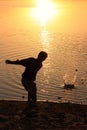 Silhouette of a boy throwing stones in a water, Khichan village, India