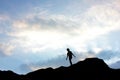 Silhouette of a boy on top of mountain at sunset.