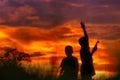 Silhouette of a 2 boys piloting a drone on A Rural Setting on sunset,There was a shadow of the grass in front of him.