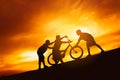 Silhouette boys riding bicycle at sunset or sunrise