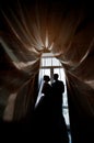 Silhouette of a bride and groom on the background of a window wi