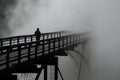 silhouette on bridge with dense fog backdrop Royalty Free Stock Photo