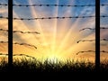 Silhouette of a broken border fence with barbed wire Royalty Free Stock Photo