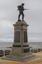 Silhouette of a bronze British Tommy statue with drawn bayonet on a UK war memorial