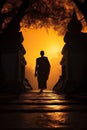 silhouette of buddhist monk walking by temple on mountain at sunset, asian spirituality concept Royalty Free Stock Photo