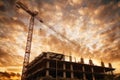 Silhouette of a building with a construction crane against the sunset and clouds. Buildings and construction concept. Royalty Free Stock Photo