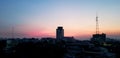 Silhouette of building and telecom or digital TV tower at sunset or sunrise time. Royalty Free Stock Photo