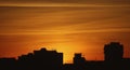 Silhouette of buildings in orange sunset, buildings silhouettes in colourful sunset, evening in the city, flaming red sky Royalty Free Stock Photo