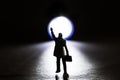 Silhouette of a business figurine waiving towards a small flashlight