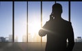 Silhouette of business man calling on smartphone