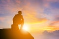 Silhouette of Business man kneeling position and looking forward on a mountain top Sunset Evening Sky Background, Success and acti