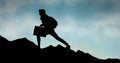 Silhouette business person walking on mountain against sky Royalty Free Stock Photo