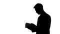 Silhouette of businessman looking through meeting planner, checking appointment