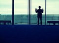 Silhouette businessman looking out window at the airport lobby Royalty Free Stock Photo