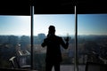 Silhouette of a businessman man in a modern office on the background of the window, a man talking on the phone Royalty Free Stock Photo