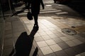 Silhouette of businessman, office guy holding bag walking to work in the morning in Tokyo, Japan