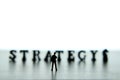 Silhouette of businessmen standing and thinking in front of strategy word