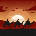 Silhouette of camel caravan traveling in desert at sunset