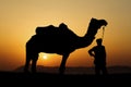 Silhouette of the Camel Trader crossing the sand dune. Royalty Free Stock Photo