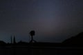 Silhouette camera on tripod with beautiful stars on night sky background.