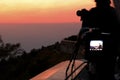 Silhouette camera on tripod with beautiful sunset on twilight sky background.