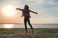 Silhouette of carefree young woman near river at sunset Royalty Free Stock Photo