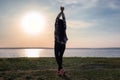 Silhouette of carefree young woman near river at sunset Royalty Free Stock Photo