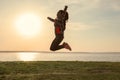 Silhouette of carefree young woman near river at sunset Royalty Free Stock Photo