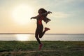 Silhouette of carefree young woman near river at sunset Royalty Free Stock Photo