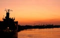 Silhouette cargo ship docked at port in sunset time Royalty Free Stock Photo