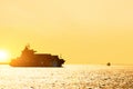 Silhouette of cargo ship with full shipload cargo containers are sailing in the Osaka bay evening