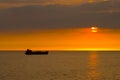 Silhouette of the cargo ship over the sunrise. Royalty Free Stock Photo