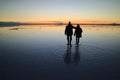 Silhouette of a caring couple exploring the incredible mirror effect of Uyuni Salt Flats, Bolivia, South America