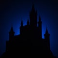 Silhouette of a castle against a deep blue night sky. The structure features multiple Royalty Free Stock Photo