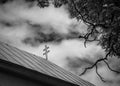 Silhouette of catholic cross on church roof with dramatic cloudy background. Royalty Free Stock Photo