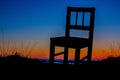 Silhouette of a chair against a gradient sky during twilight