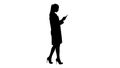 Silhouette Cheerful cute young woman doctor typing text on phone while walking. Royalty Free Stock Photo