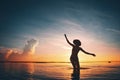 Silhouette of woman dancing in the ocean at sunset Royalty Free Stock Photo