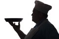Silhouette of a chef carrying a dish in pan on his hand on a white isolated background, good-natured man`s profile in a chef`s h