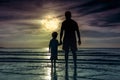 Silhouette of child holding hands her father, standing in the se Royalty Free Stock Photo