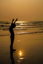 Silhouette of child holding his hands up on the beach