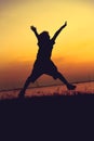 Silhouette of child jumping against sunset. Boy enjoying the vie Royalty Free Stock Photo