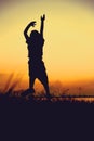 Silhouette of child jumping against sunset. Boy enjoying the vie Royalty Free Stock Photo