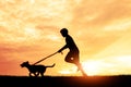 Silhouette child playing with dogs.