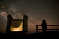 Silhouette of a child staring at the night sky and telescope dome