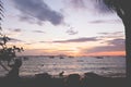 Silhouette of children of fisherman town play on the beach in sunset.